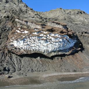 Cliff with layers of ice and dirt.