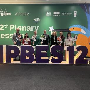 Group of people posing in front of a conference sign.