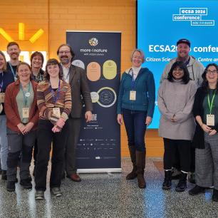 Group of people smiling, posing for a photo.