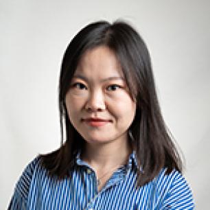 Woman with dark hair in a striped shirt, looking forward. 