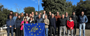 Group of people holding a flag with the LIFE Programme logo.