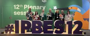 Group of people posing in front of a conference sign.
