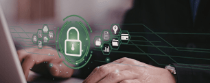 Una persona trabajando con un ordenador portátil con iconos de seguridad, que simbolizan la protección de datos.