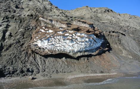 Cliff with layers of ice and dirt.