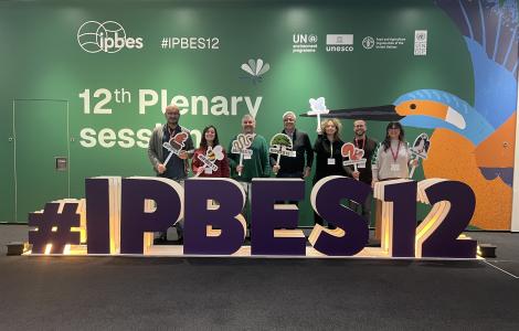 Group of people posing in front of a conference sign.