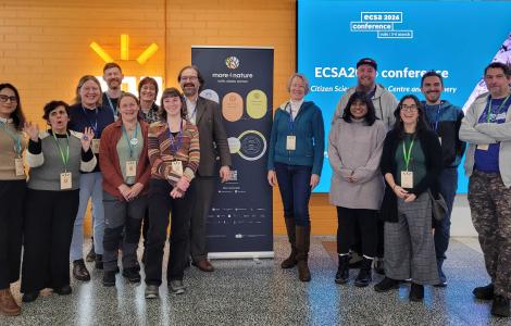 Group of people smiling, posing for a photo.