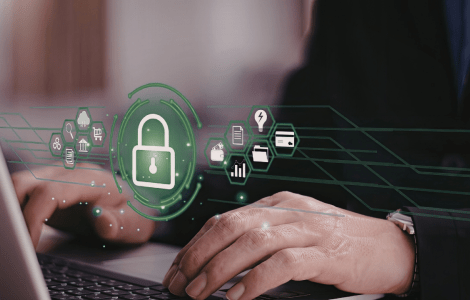 Una persona trabajando con un ordenador portátil con iconos de seguridad, que simbolizan la protección de datos.