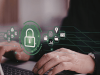 Una persona trabajando con un ordenador portátil con iconos de seguridad, que simbolizan la protección de datos.