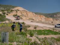 Two people hiking near a dirt road and construction site.
