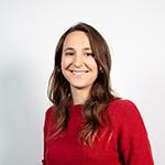 Smiling woman with long brown hair, wearing a red sweater.