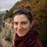 Smiling woman with sunglasses on head, outdoors.