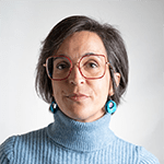 Woman with glasses and earrings, looking at the camera.