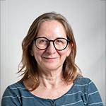 Portrait of a woman wearing glasses, smiling.