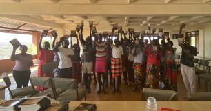 Group of people holding books up in celebration.