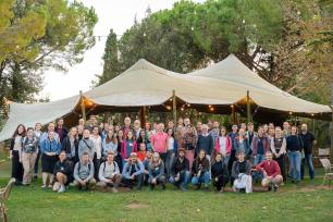 Group photo of people gathered under a large tent.