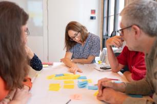 People collaborating around a table with sticky notes.