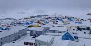 Snowy Greenland town with colorful houses.