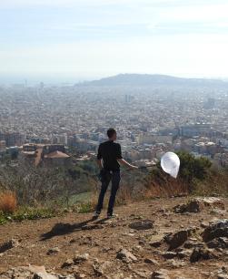 Home d'esquenes subjectant un caçapapallones amb Barcelona de fons