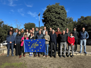 Group of people holding a flag with the LIFE Programme logo.