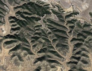 Aerial photograph of a hilly, arid landscape.