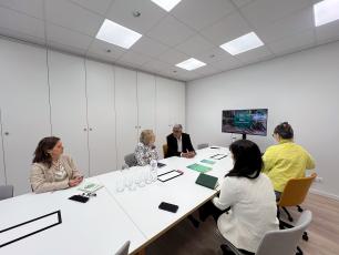 Meeting in a modern office, gathered around a large white table.