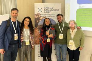 Group of five people posing for photo at a conference.