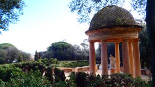 Landscape photograph of a classical pavilion in a garden.