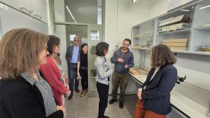 A group of people standing and talking in a laboratory.