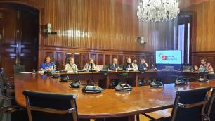 Un grup de persones assegudes al voltant d'una gran taula del Parlament parlen sobre la Llei de seguretat climàtica de Catalunya