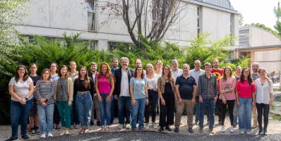 Group of people posing for a photo, outside a building.